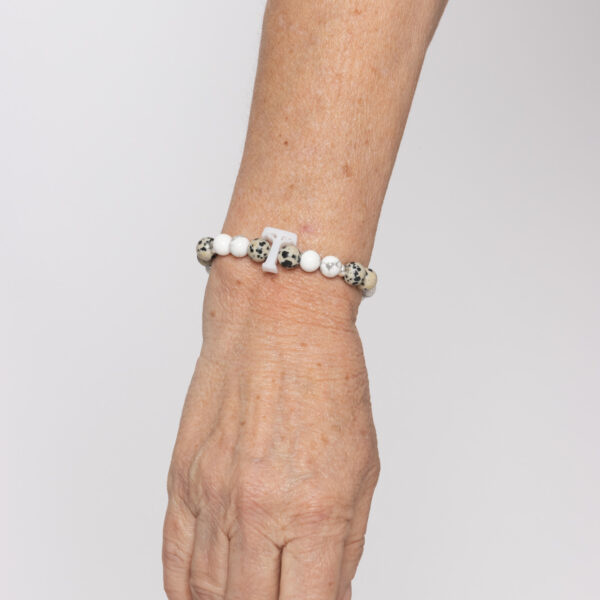 Pulsera KORU Esencial: Howlita, jaspe dálmata, cuentas con baño de plata y logo de metacrilato. (Nuevos comienzos)